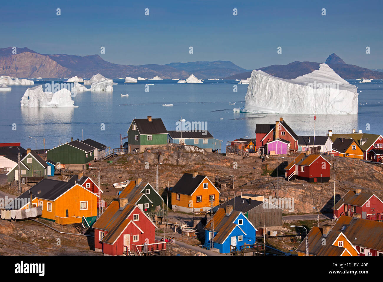 Uummannaq village with colourful houses and icebergs in the fjord