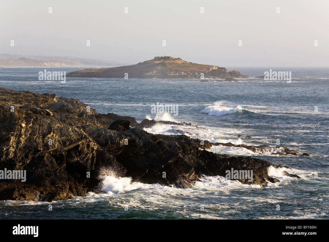 Pessegueiro Island seen from the rocky coastline of Porto Covo on Portugal's Alentejo coast. Stock Photo