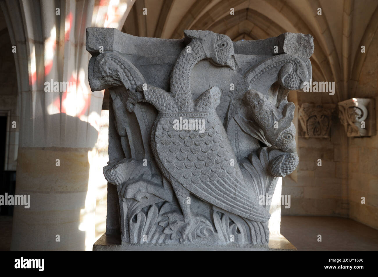Statue carving of legendary medieval web footed bird with three heads two of which have been mutilated Autun Cathedral France Stock Photo