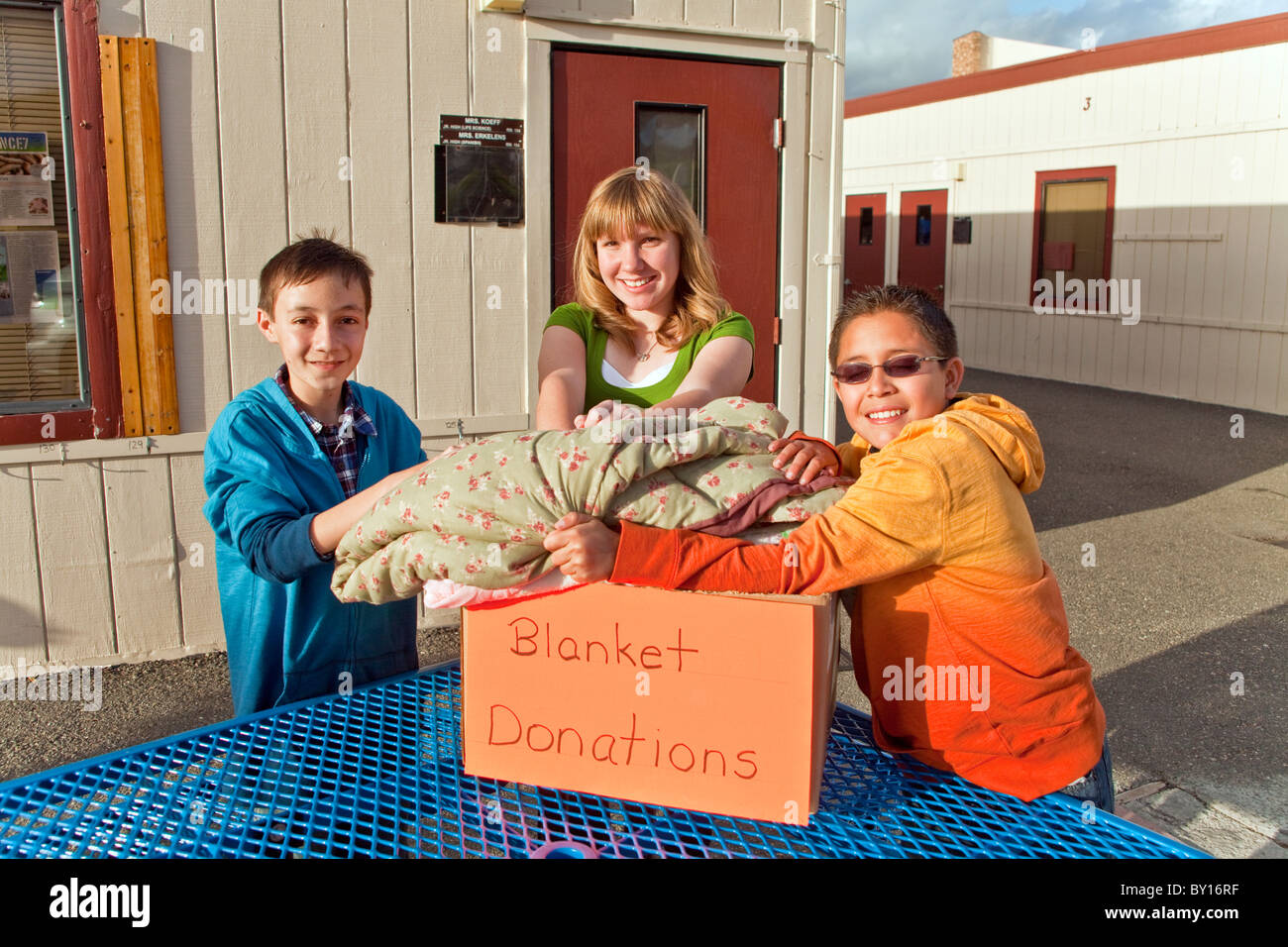 multi ethnic racial diversity racially ethnically diverse multicultural multi cultural  group Middle school kids collect blankets for poor people. Stock Photo
