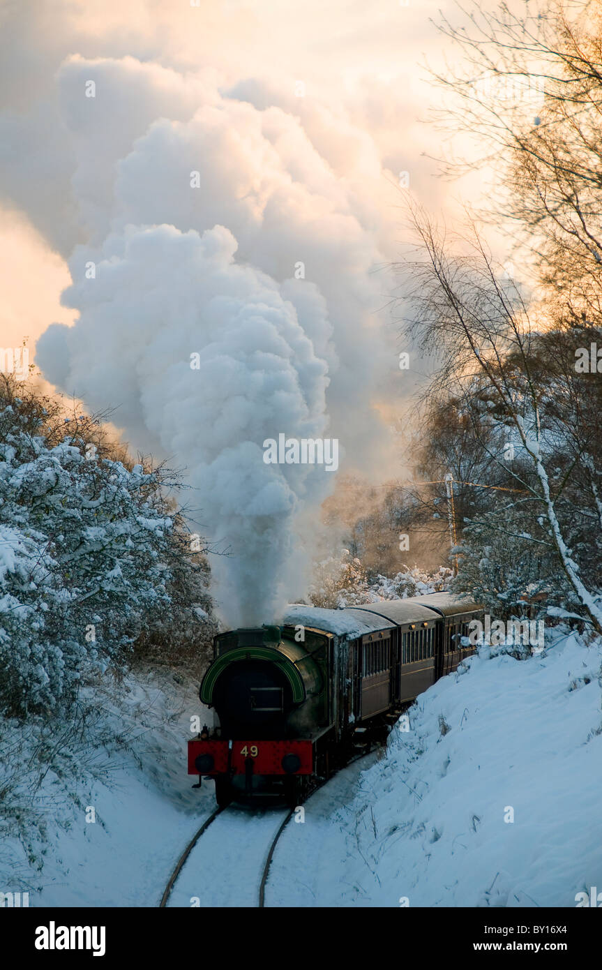 steam locomotive bellowing steam in the snow Stock Photo