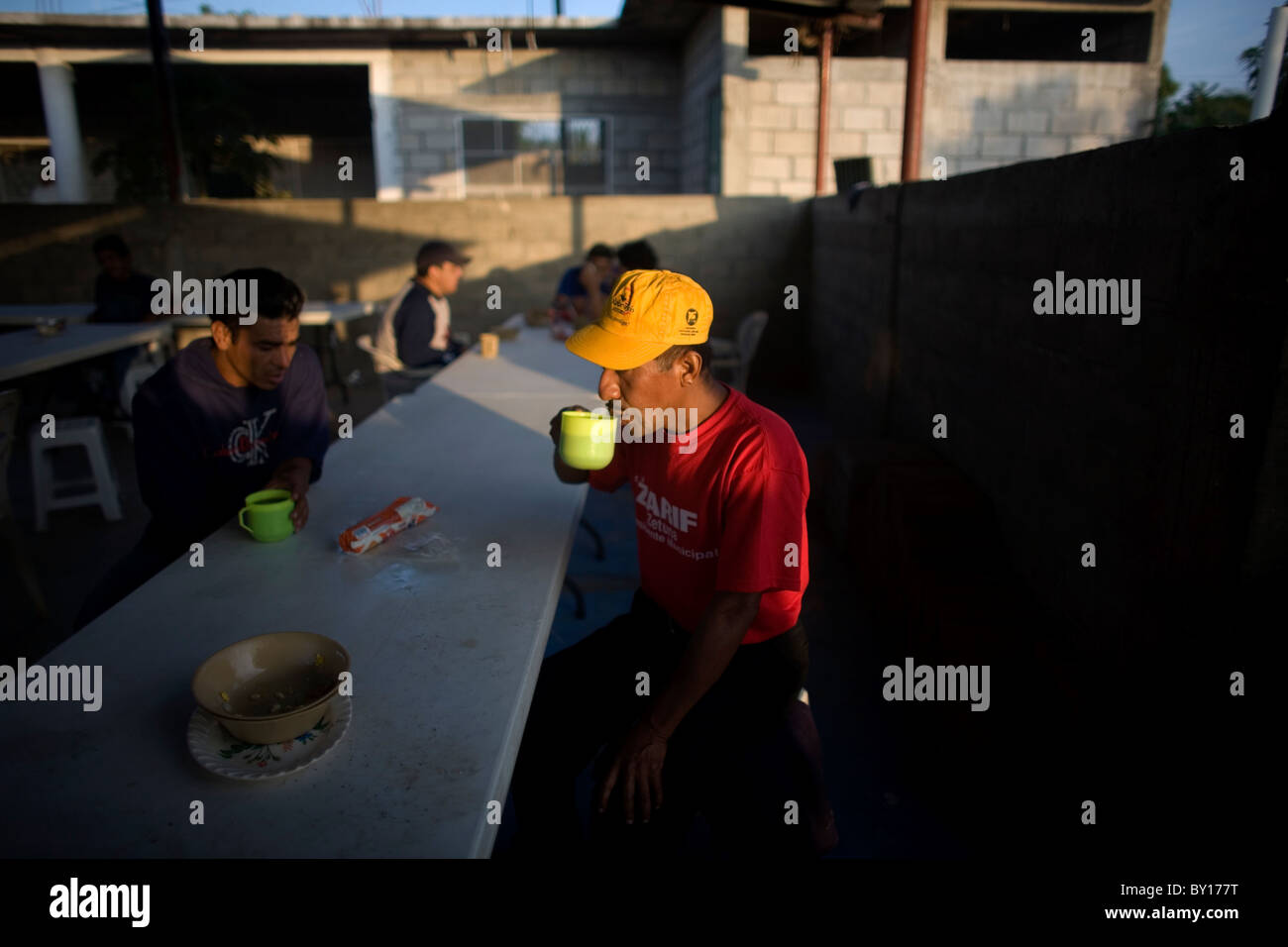 A Central American migrant drinks coffee in a shelter located along the railroad in Ixtepec, Oaxaca, Mexico. Stock Photo