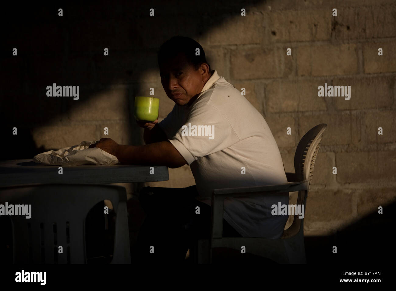 A Central American migrant drinks coffeein a shelter located along the railroad in Ixtepec, Oaxaca, Mexico. Stock Photo