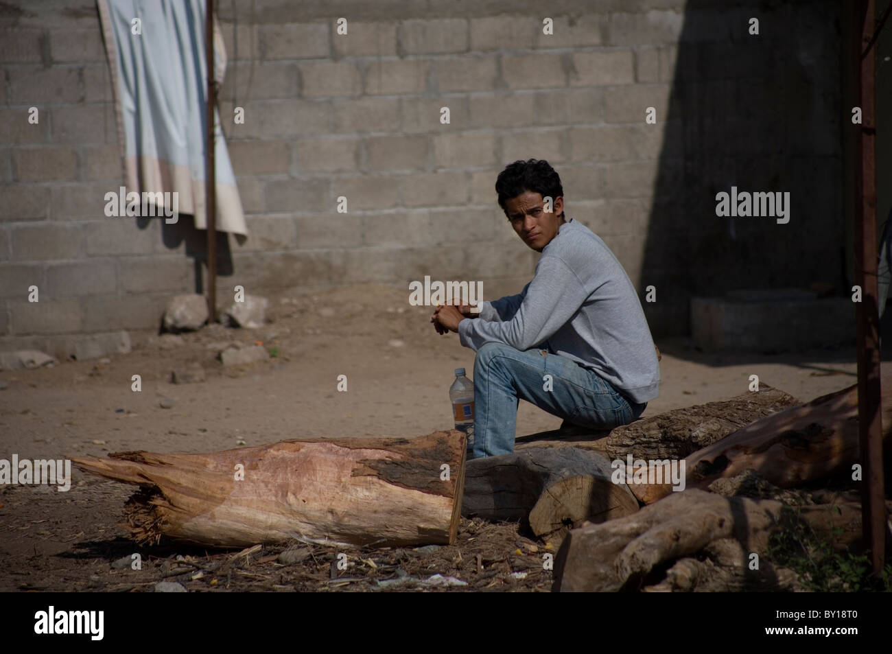 A Central American migrant sits in a shelter located along the railroad in Ixtepec, Oaxaca, Mexico. Stock Photo