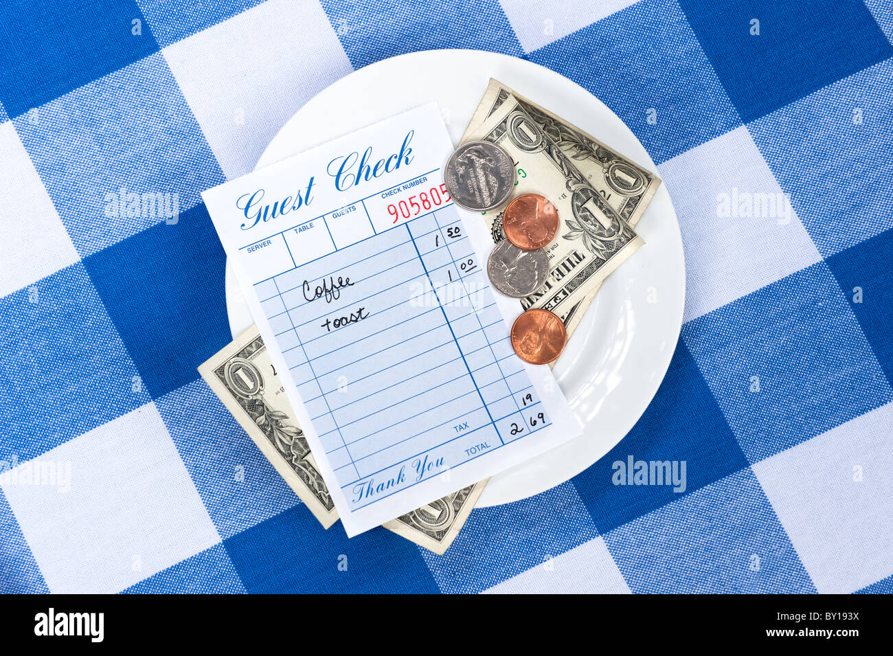 A dining check on a saucer with change from a meal payment. Stock Photo