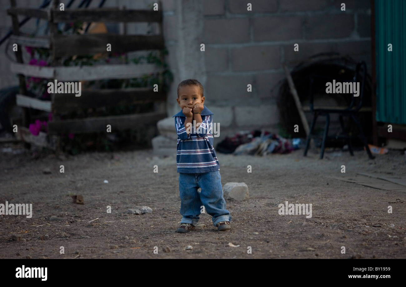 A Central American migrant boy stands in a shelter located along the railroad in Ixtepec, Oaxaca, Mexico. Stock Photo