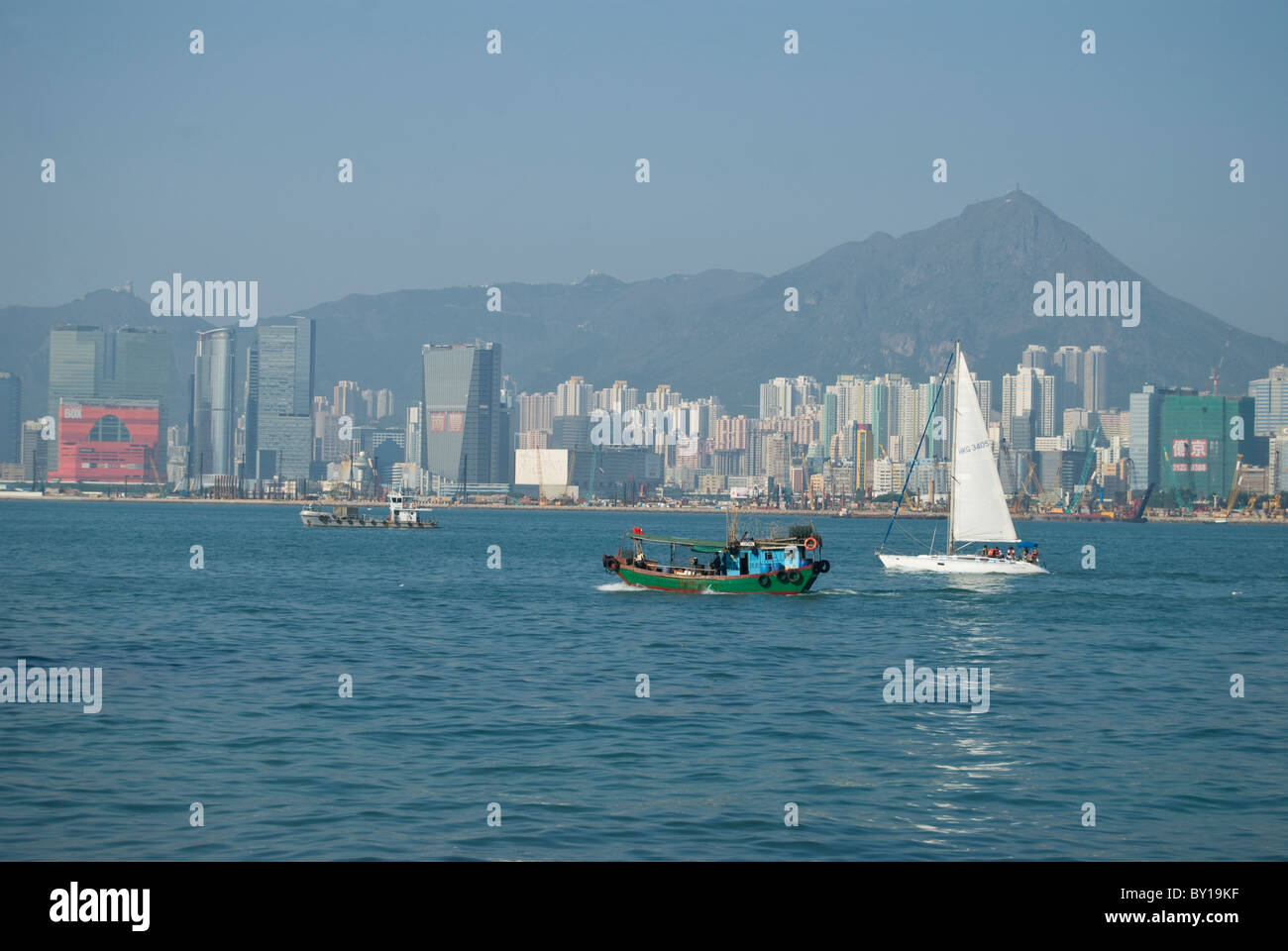 Old Sampan boat and modern sailboat can be seen in Hong Kong waters Stock Photo