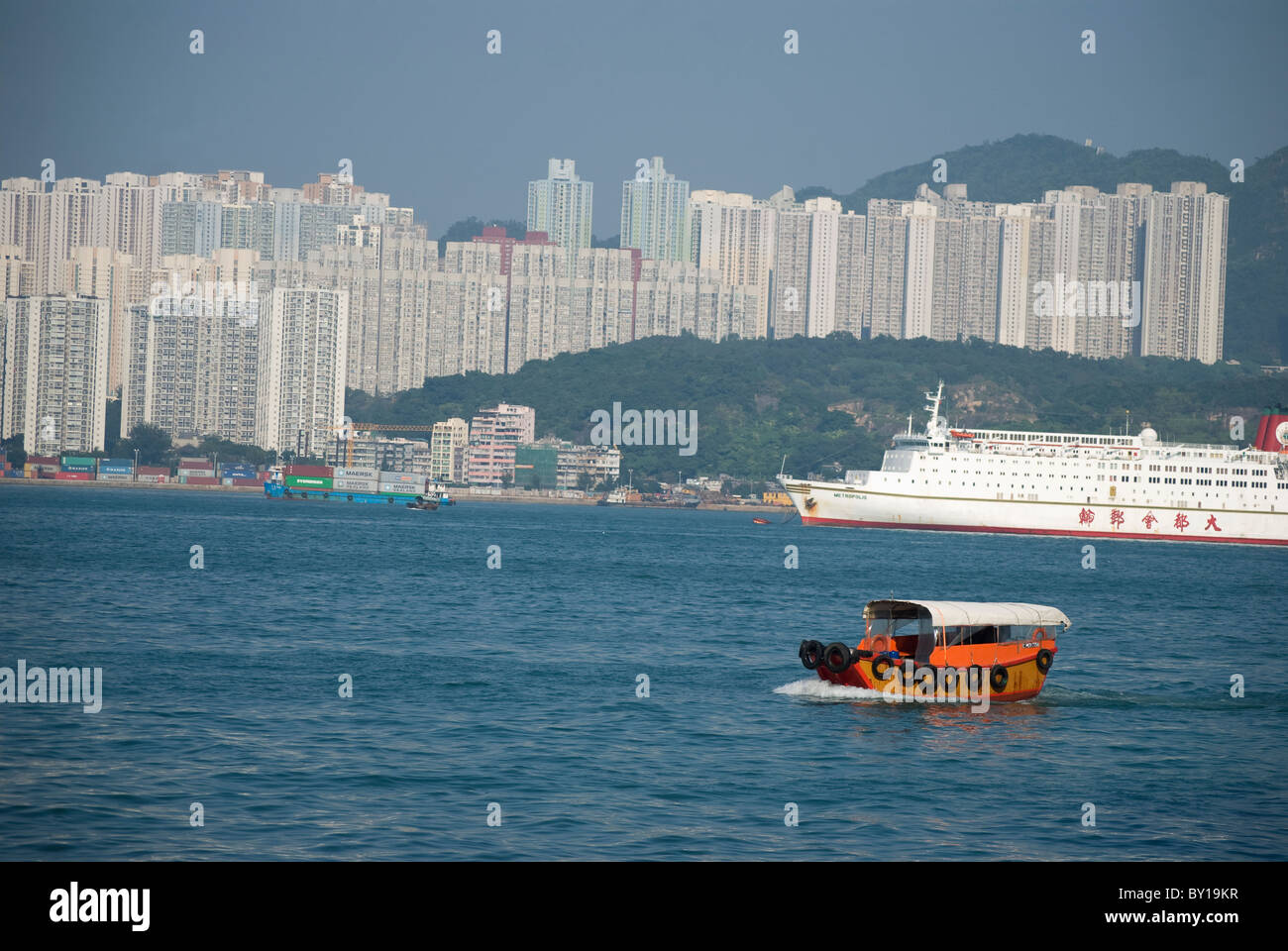 Red Sampan boat in the inland waters of Hong Kong and high buildings Stock Photo