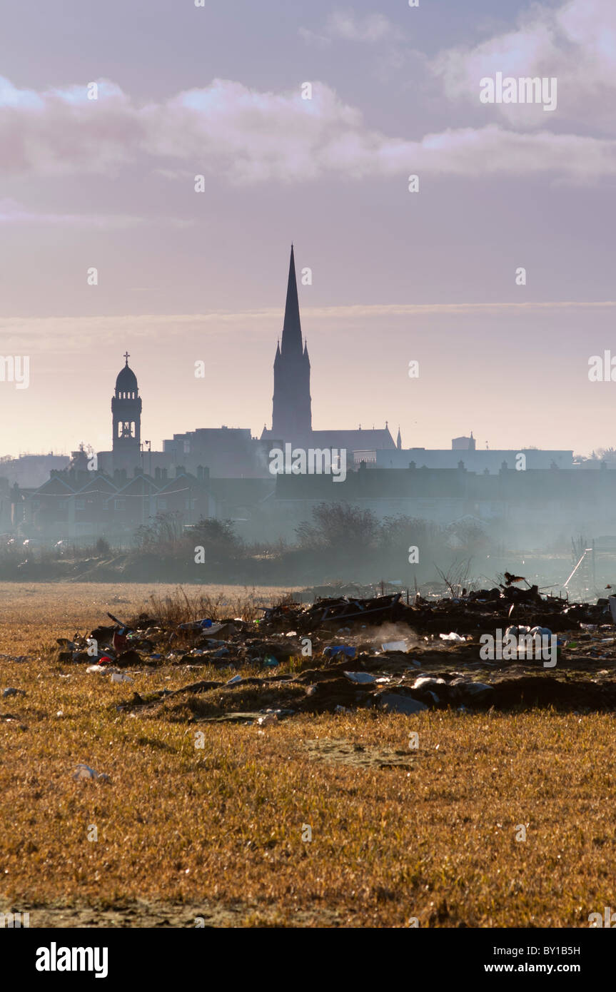 A distant Limerick city centre skyline with dumped rubbish near a