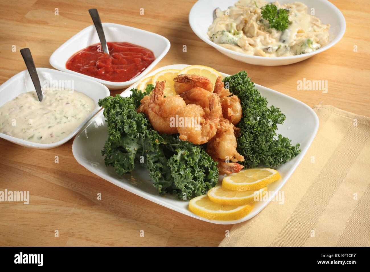 fried shrimp dinner with sauce and pasta bowl Stock Photo