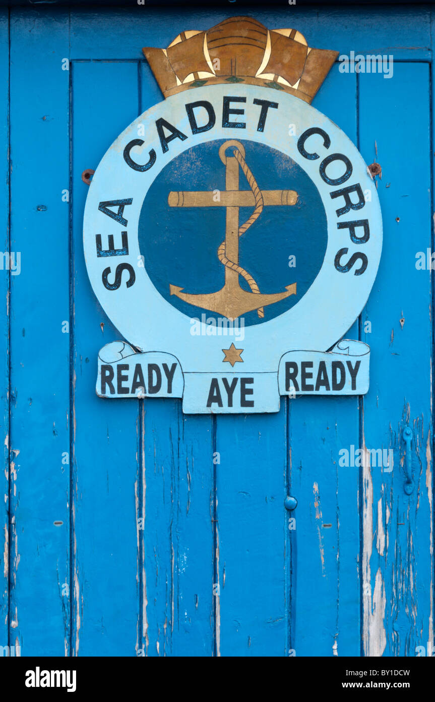 The insignia of the Sea Cadet Corps on a weatherbeaten blue door Stock Photo