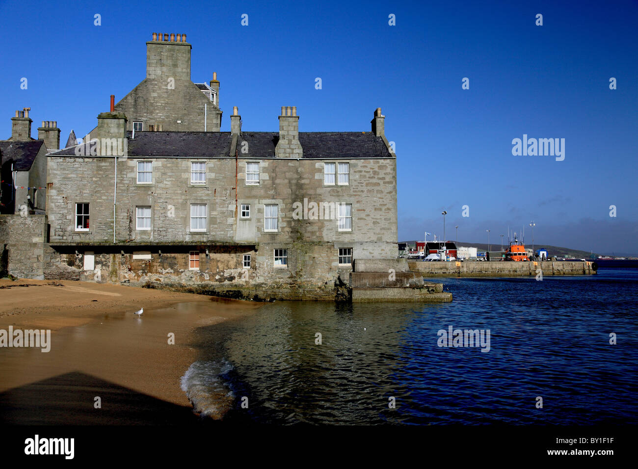 A small sandy bay and houses by the harbour, Bressay Sound, on