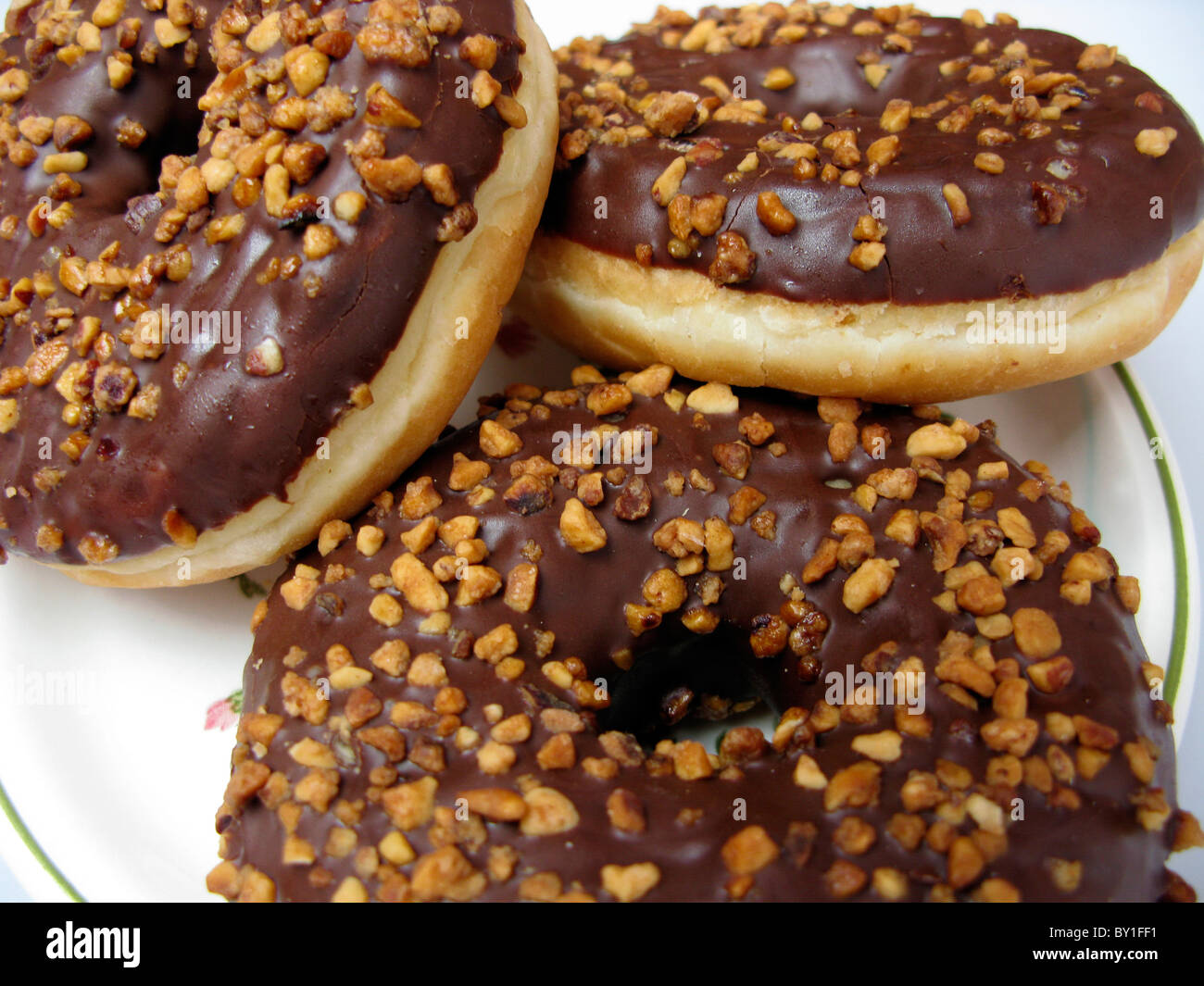 chocolate covered doughnuts on a plate Stock Photo