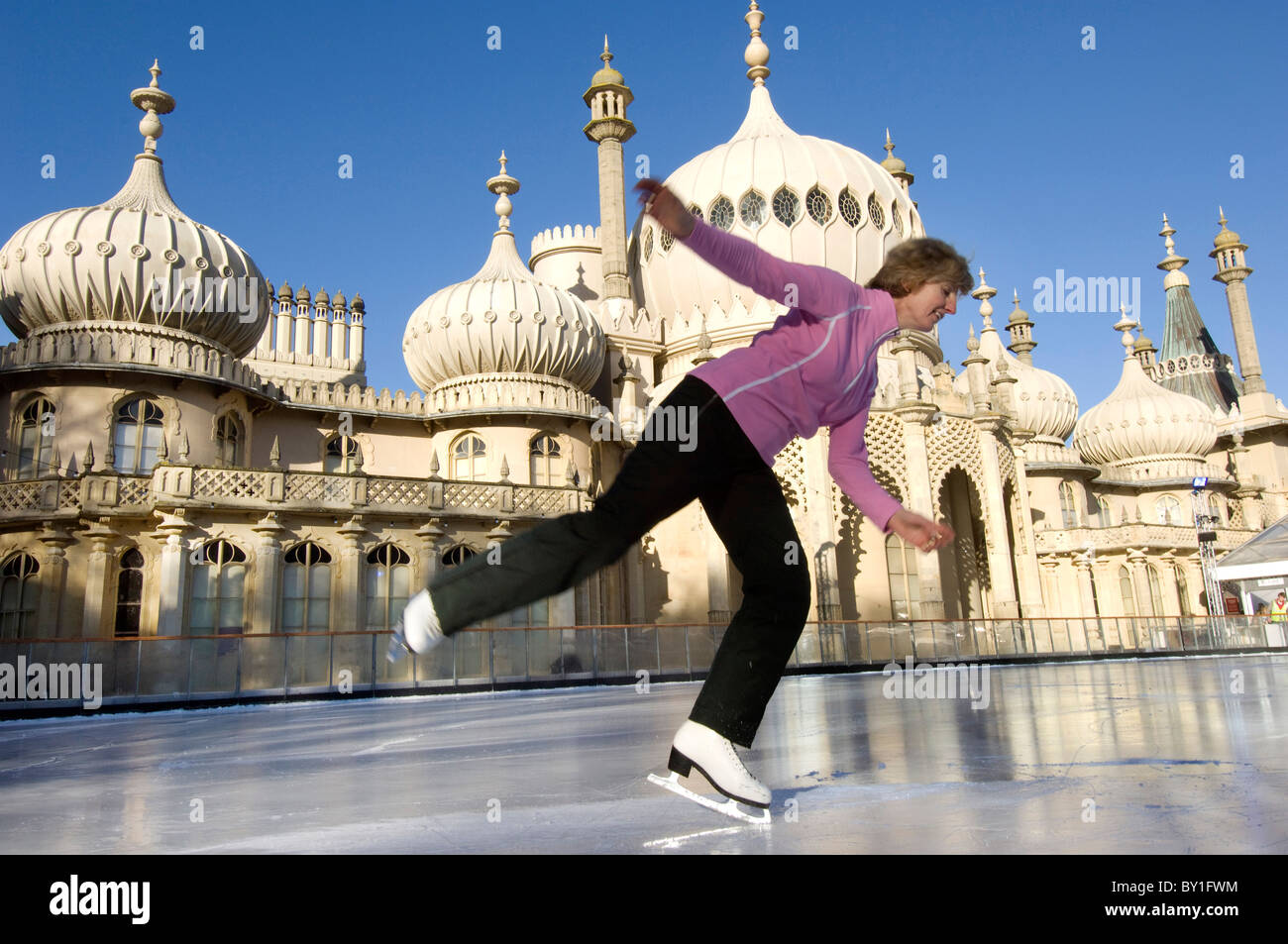 A woman skater on the temporary pop-up ice skating rink in front of the Brighton Royal Pavilion. Stock Photo