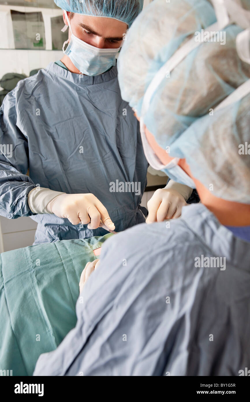 Surgeon with assistant performing operation - live surgery Stock Photo