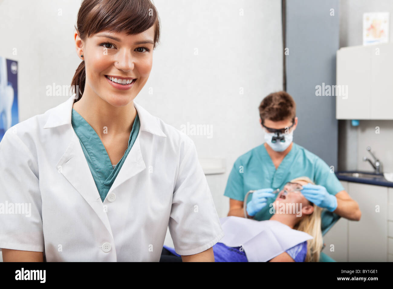 Portrait of dental assistant smiling with dentistry work in the background Stock Photo