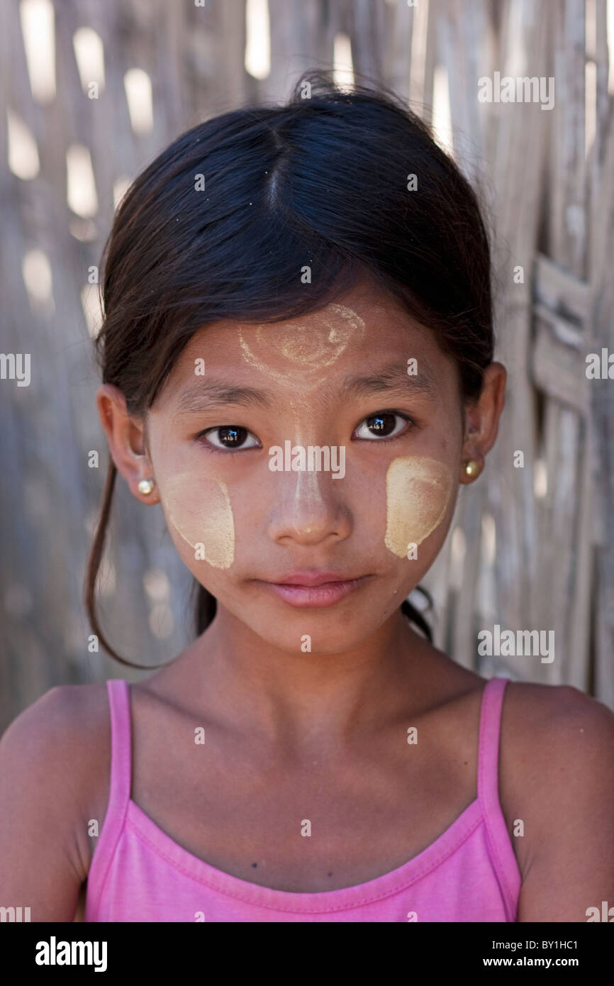 Myanmar, Burma, Mrauk U. Young village girl with her face decorated with thanaka, a local sun cream made from ground bark, Stock Photo