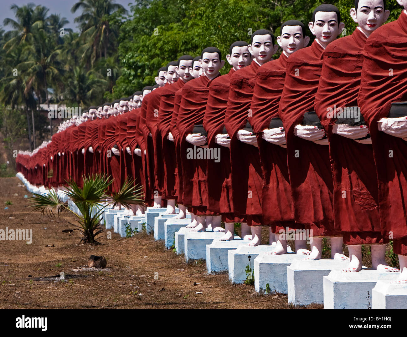 Myanmar, Burma, Pegu, Bago. A line of monk statues leading to Win Sein Taw Ya, the site of the world's largest reclining Buddha Stock Photo