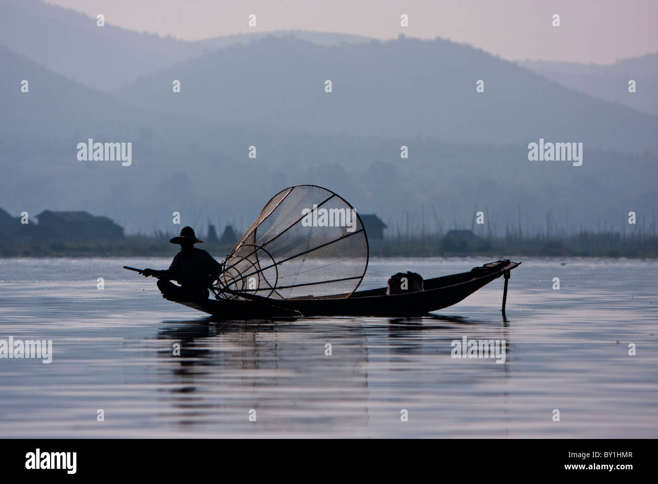 Myanmar, Burma, Lake Inle. An Intha fisherman, with his traditional conical net, quietly watching for fish in the waters of Stock Photo
