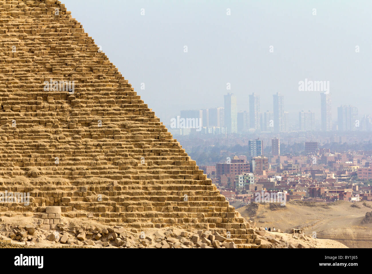 Pyramids at Giza, Egypt- Menkaure and skyscrapers of Cairo in hazy background Stock Photo