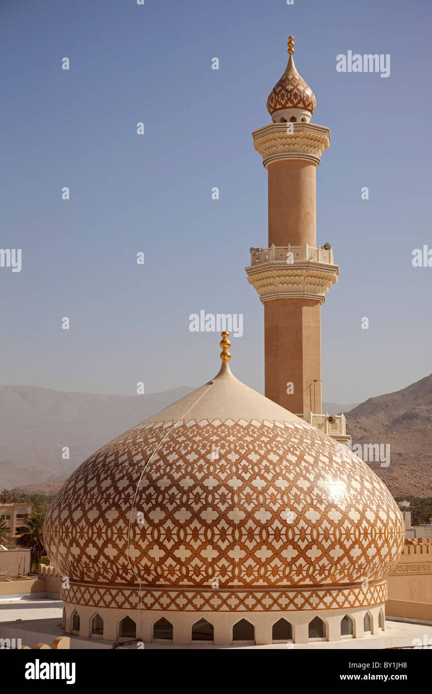 Oman, Nizwa. The iconic dome and minaret of Nizwa Mosque are often used to symbolise Oman. Shown here with the new terracotta Stock Photo