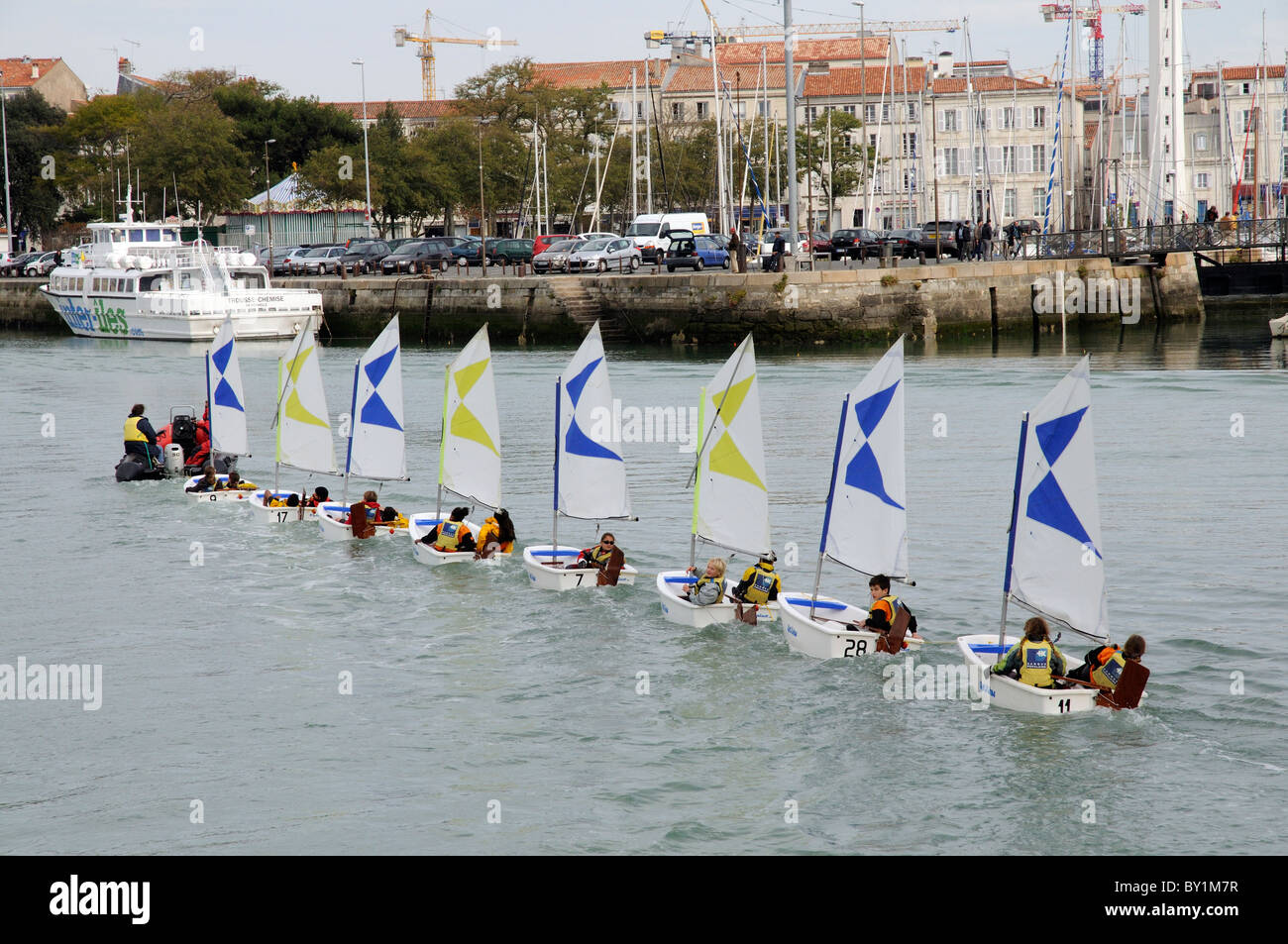 Young children in dinghies return under tow to La Rochelle harbour in western Franc Stock Photo