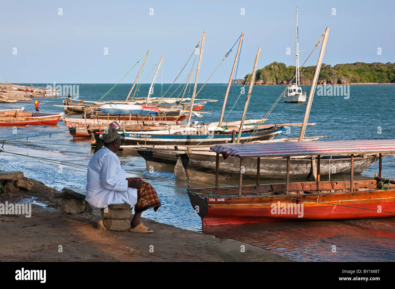 Traditional wooden boats and a yacht anchored at the mouth of the Pangani River. Stock Photo
