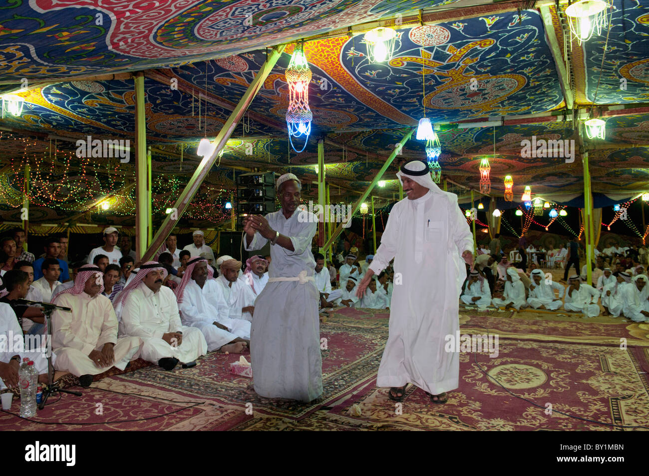 Guests celebrate with dance as other guests look on during a traditional Bedouin wedding celebration. El Tur, Sinai, Egypt Stock Photo