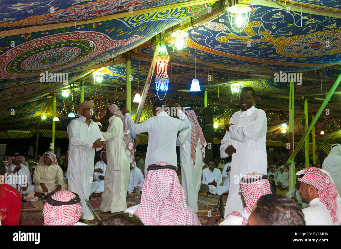 Guests celebrate with dance as other guests look on during a traditional Bedouin wedding celebration. El Tur, Sinai, Egypt Stock Photo