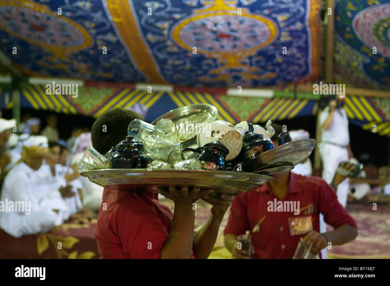 Waiters collect soiled dishes during a traditional Bedouin wedding celebration. El Tur, Sinai Peninsula, Egypt Stock Photo