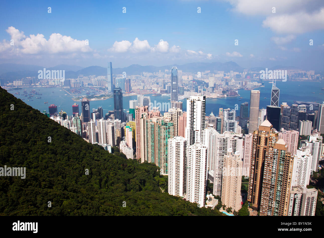 The infamous Victoria Peak of Hong Kong taking in the skyline also of Kowloon and Victoria Harbour on a summer day with blue sky Stock Photo
