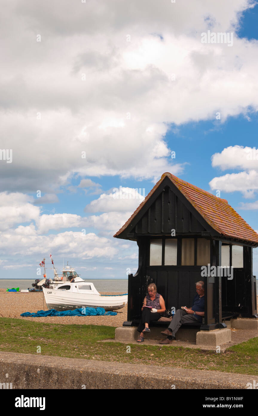 A couple relax on the seafront in the summer at Aldeburgh , Suffolk , England , Great Britain , Uk Stock Photo