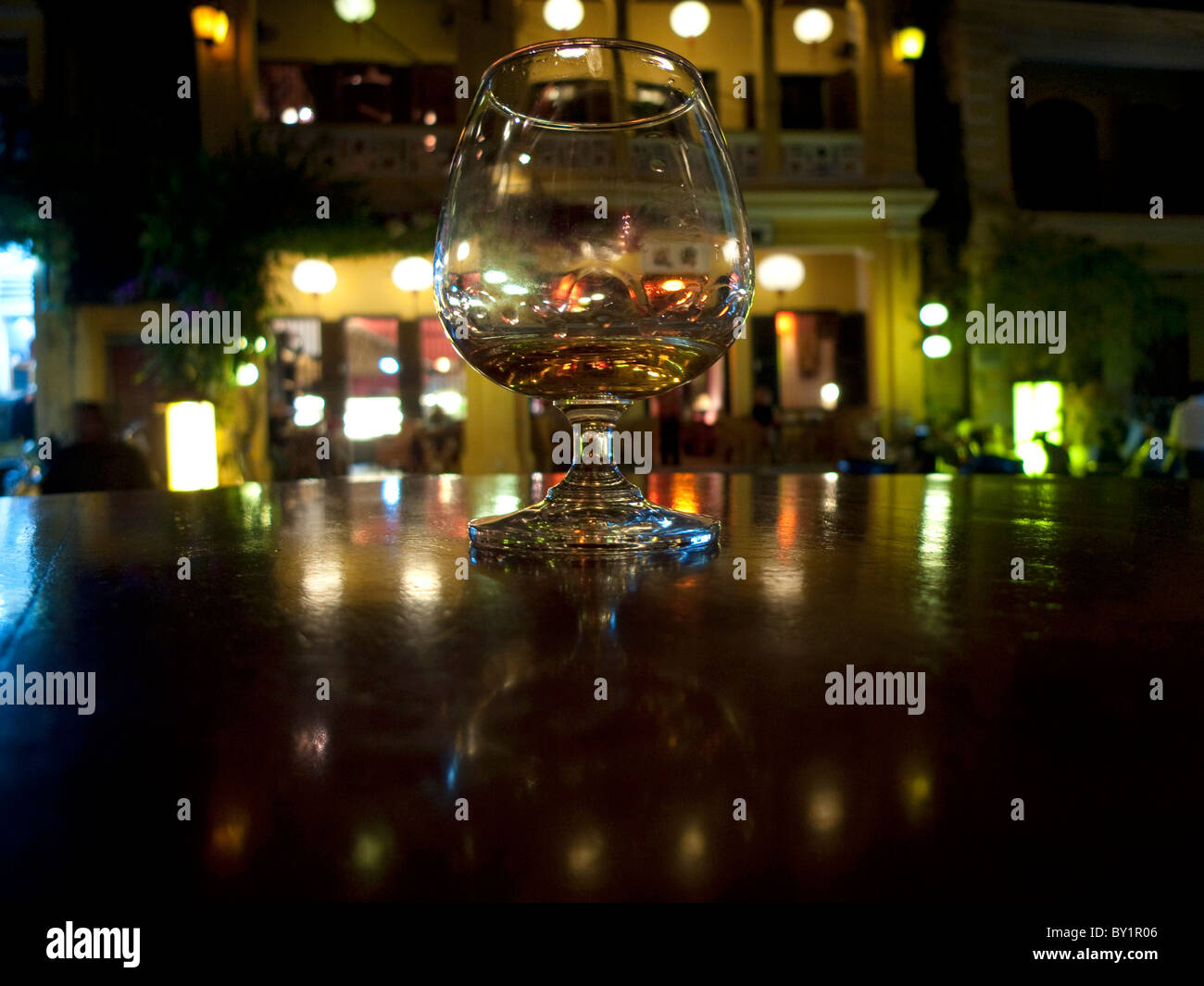 Glass on table at night, Hoi An, Vietnam Stock Photo