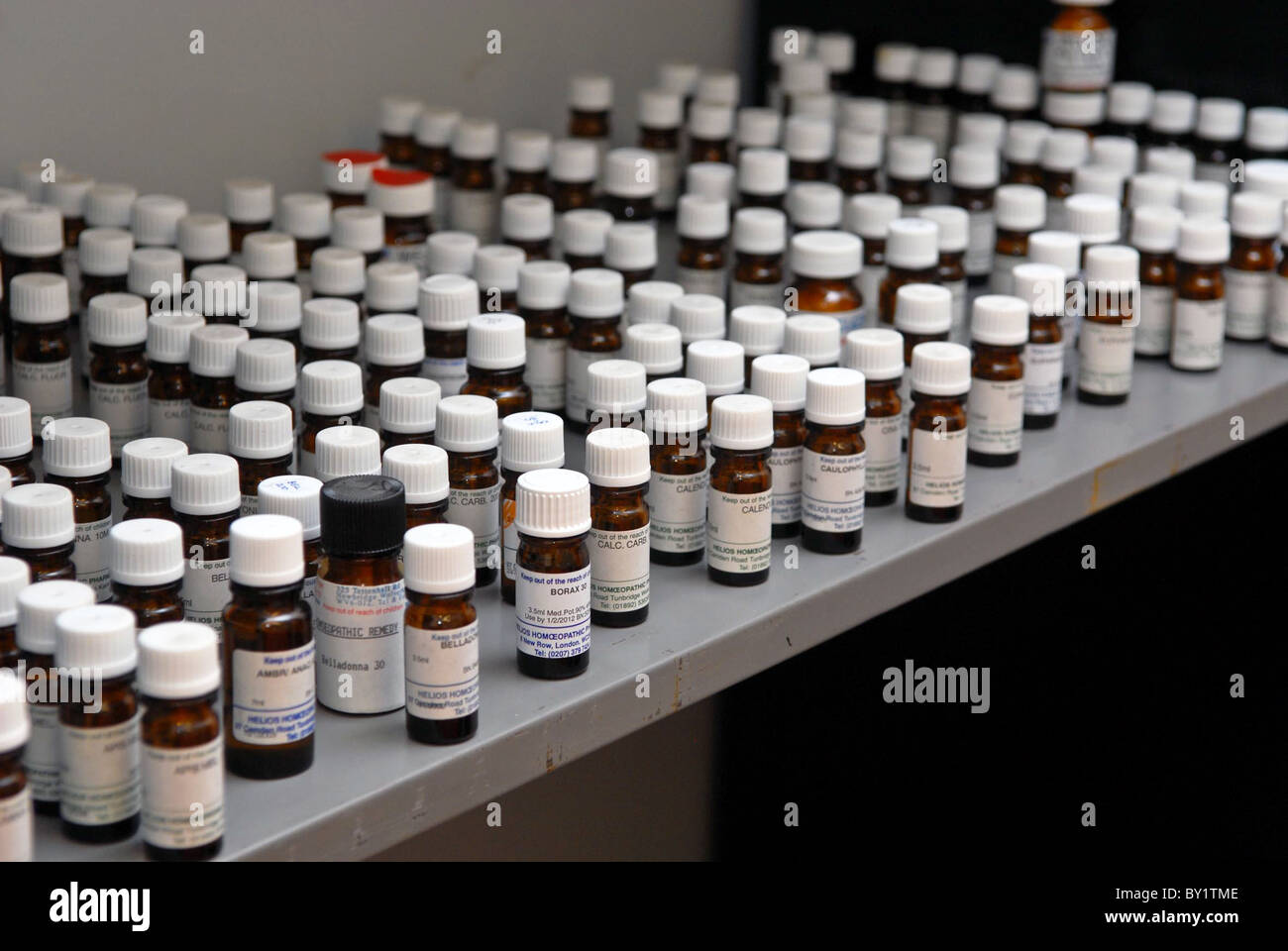 Rows of little brown homeopathic remedy bottles lined up in a medicine