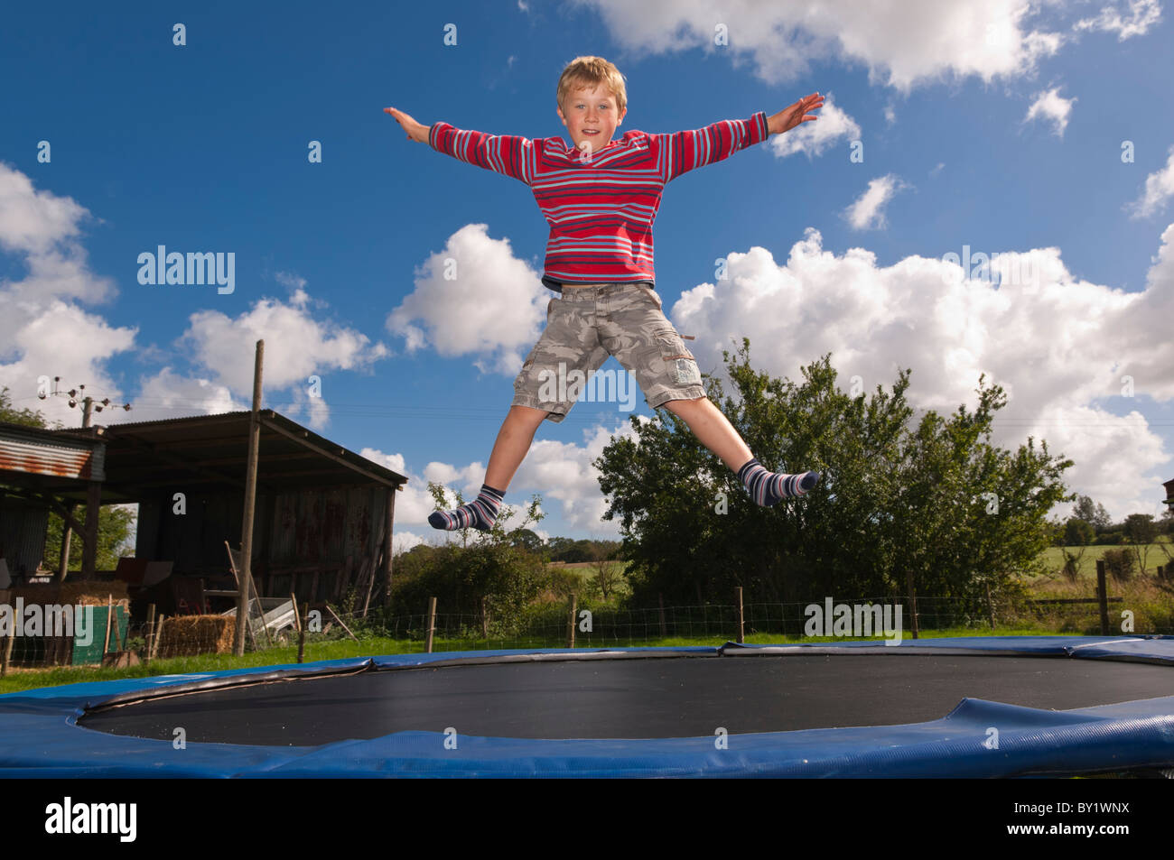 A MODEL RELEASED seven year old boy jumping on a trampoline in the Uk