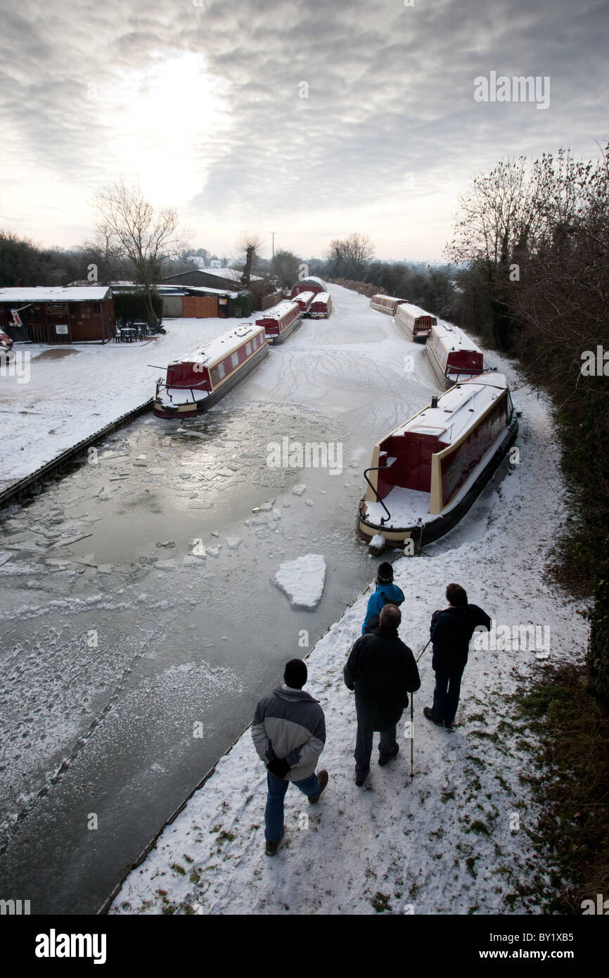 Freezing conditions led to the canals being frozen. Pictured, walkers view the frozen canal near Stoke Golding, Leicestershire. Stock Photo