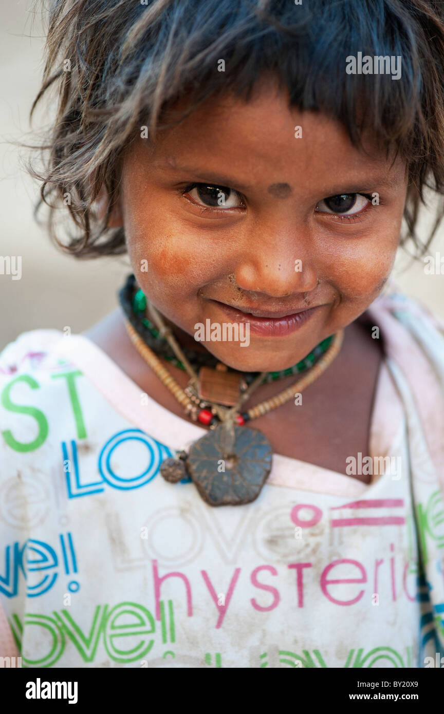 Happy young poor lower caste Indian street girl smiling wearing a t-shirt with colorful LOVE design. Andhra Pradesh, India. Selective focus Stock Photo