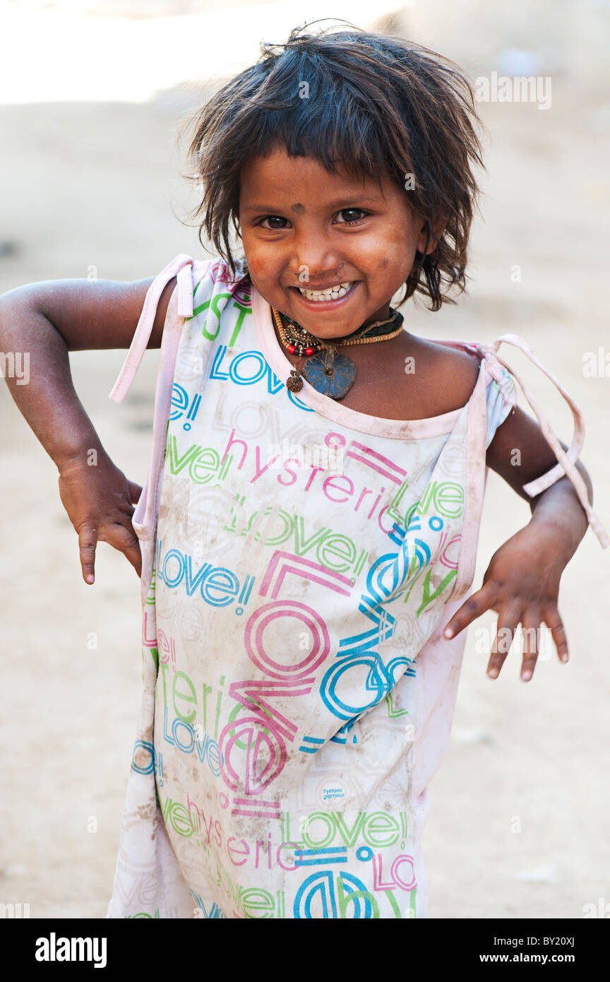 Happy young poor lower caste Indian street girl smiling wearing a t-shirt with colorful LOVE design. Andhra Pradesh, India Stock Photo