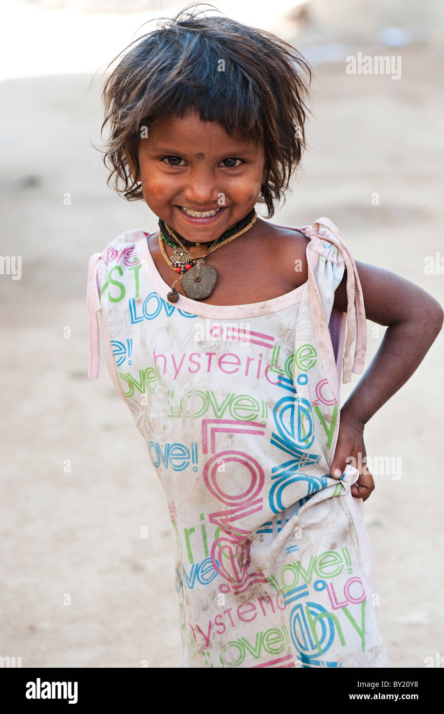 Happy young poor lower caste Indian street girl smiling wearing a t-shirt with colorful LOVE design. Andhra Pradesh, India Stock Photo