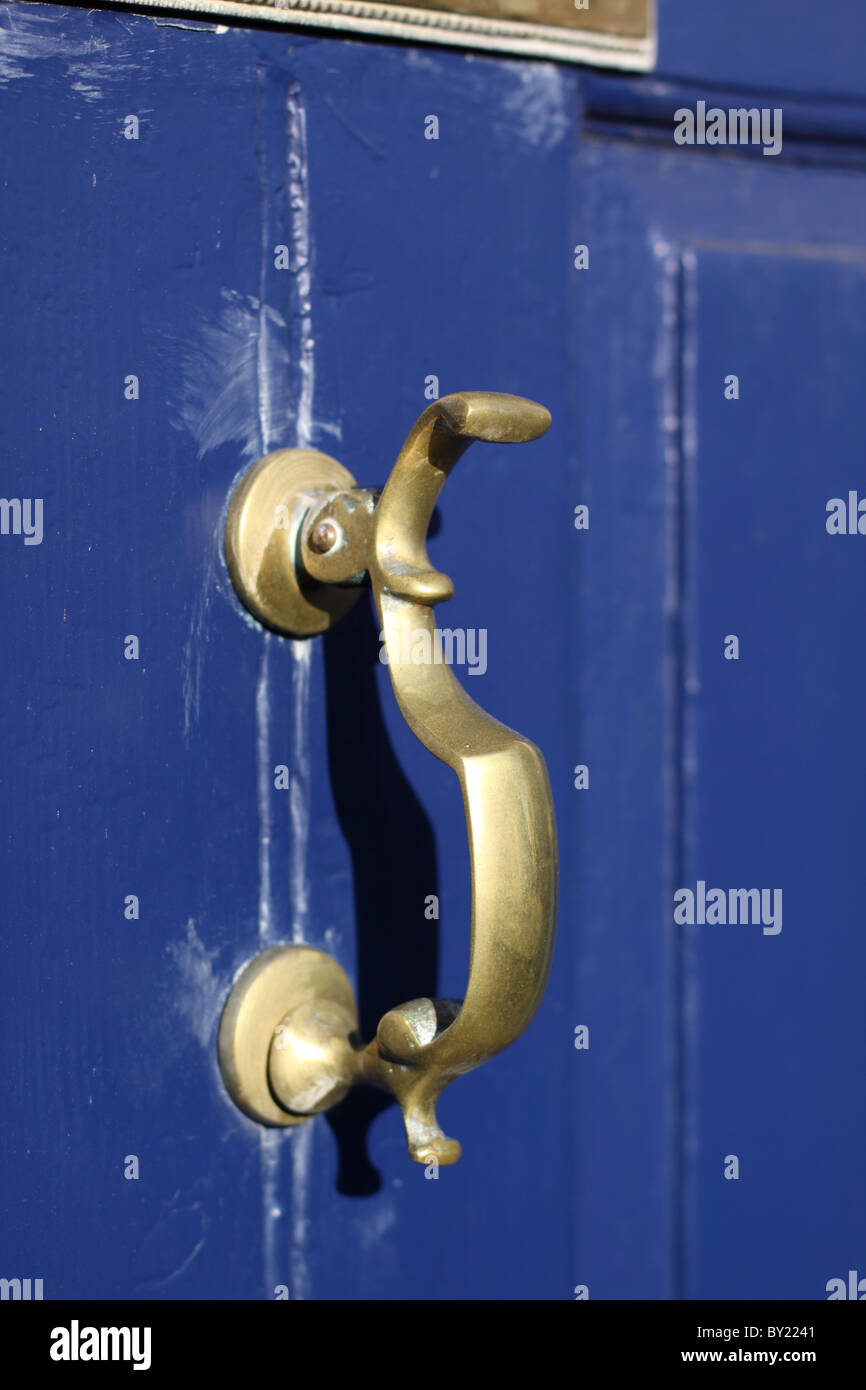 Brass door knocker on blue door. Stock Photo