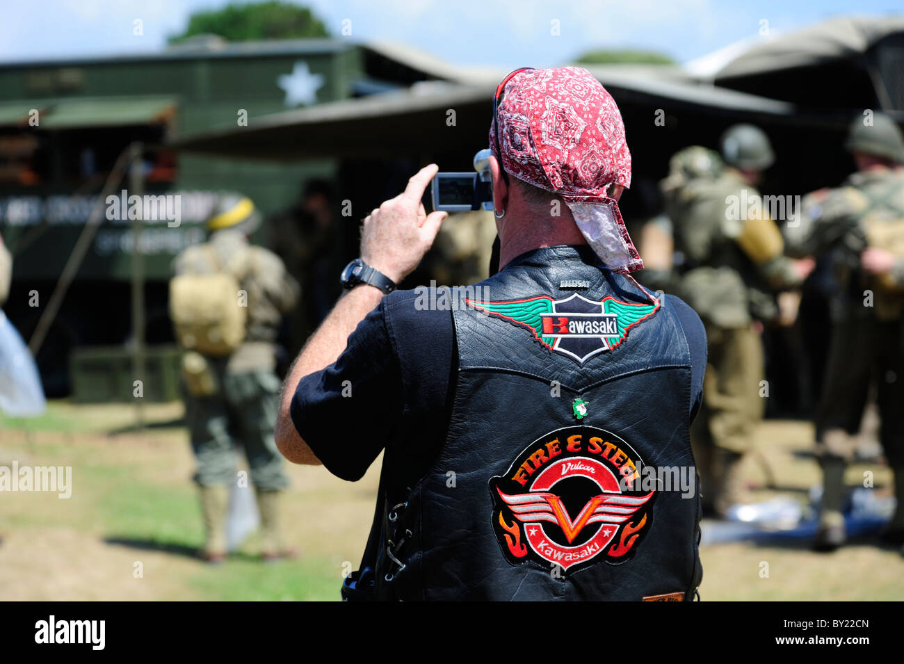A Harley Davidson enthusiast photographs role players during a D-Day re-enactment at Lepe Country Park, New Forest, England, UK. Stock Photo