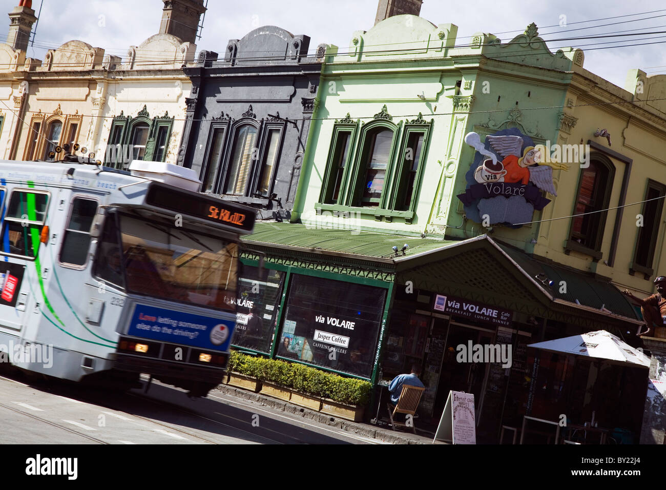 Australia, Victoria, Melbourne, Fitzroy.  City tram and colourful shops along Brunswick Street. Stock Photo