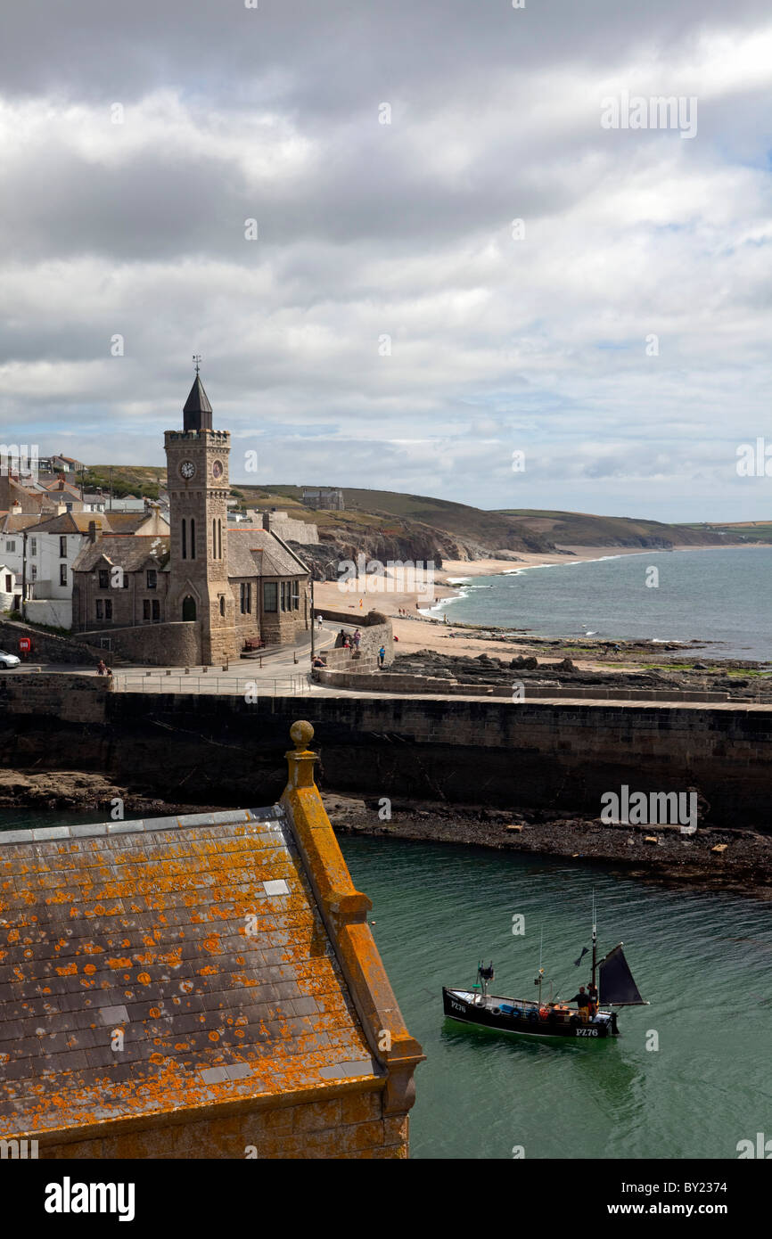 England, Cornwall, Porthleven Harbour entrance, a traditional fishing boat in Cornish colours sails back into port Stock Photo