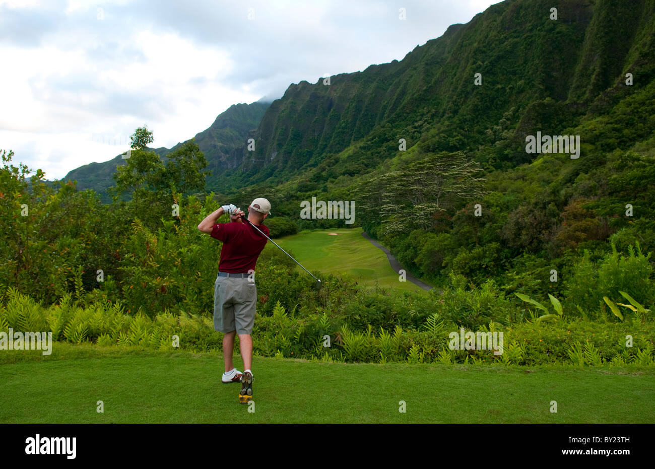 Golfer driving from beautiful elevated 15th hole of famous Ko'olau Golf