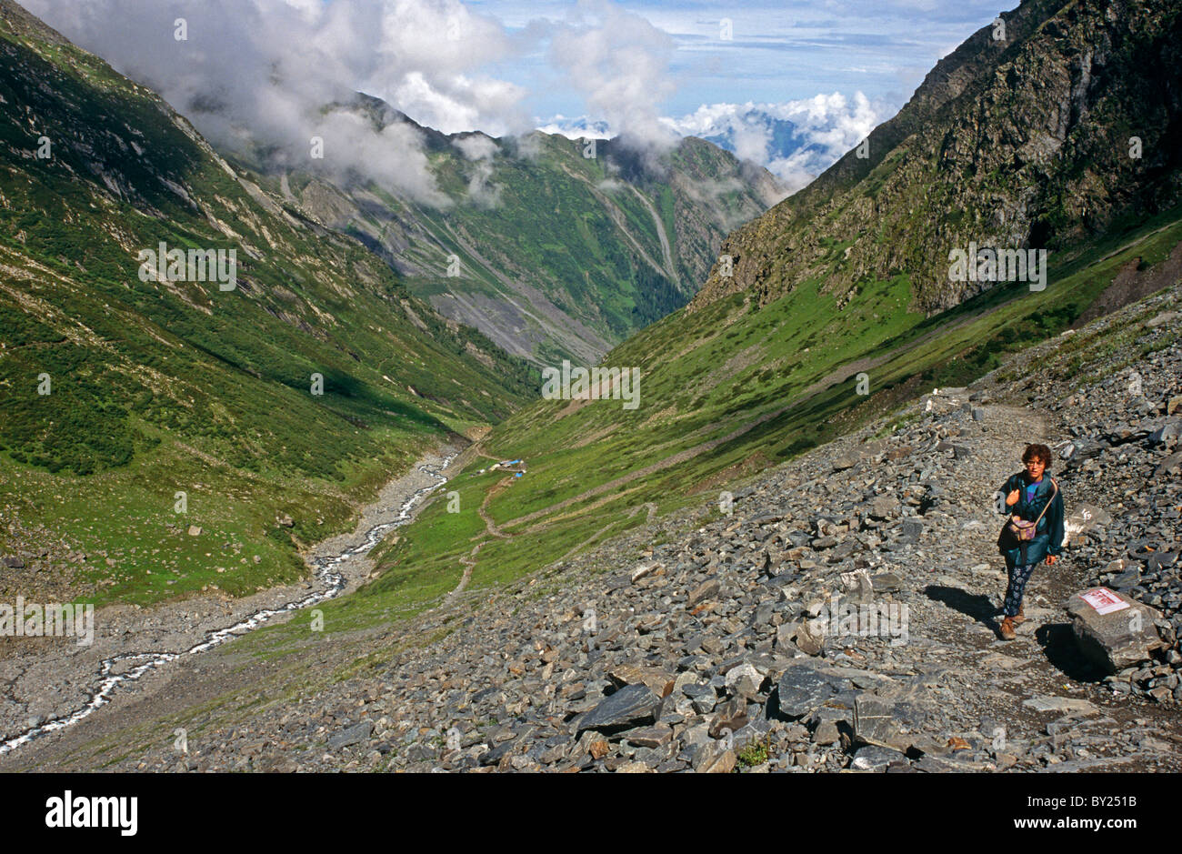 India, Himachal Pradesh, Chamba Valley, Mani Mahesh. A trekker ascends the steep Hindu pilgrimage trail beside the Mani Mahesh Stock Photo