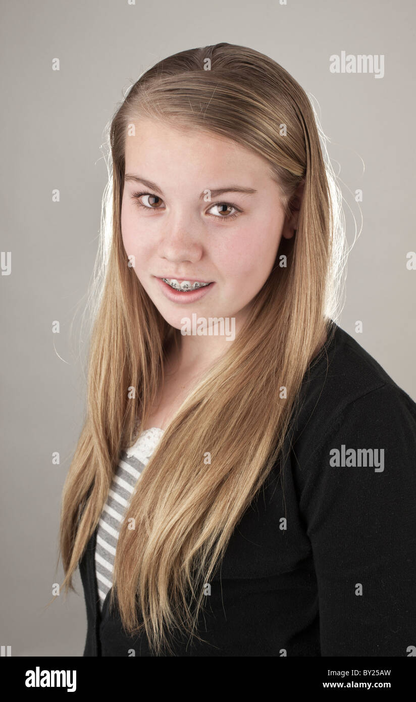 Studio portrait of a teenage girl smiling with braces Stock Photo - Alamy