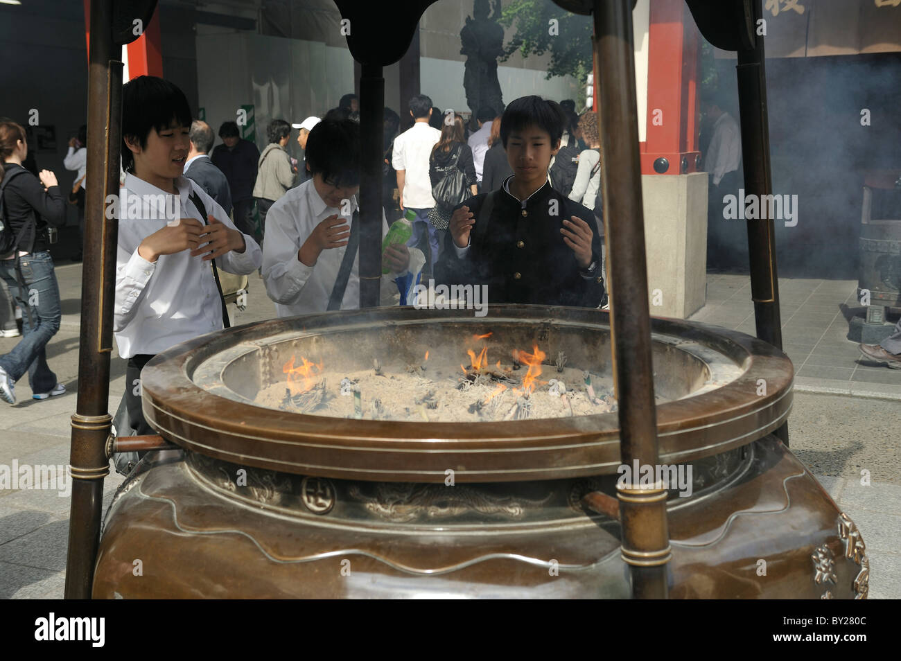 Japanese schoolboys at incense bowl for purification at Sanja Matsuri