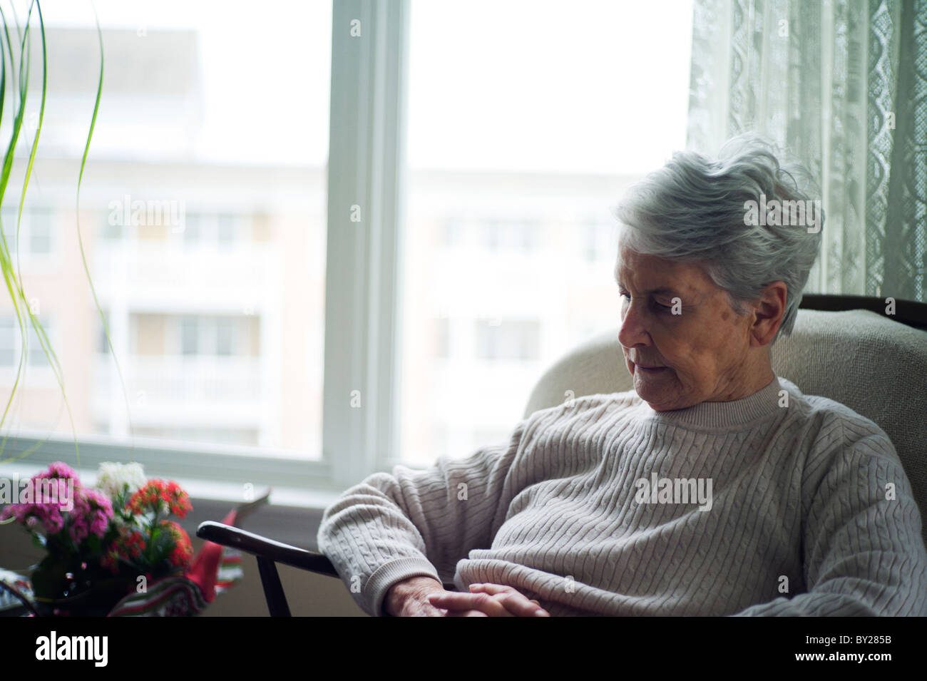 Old woman sitting in chair Stock Photo