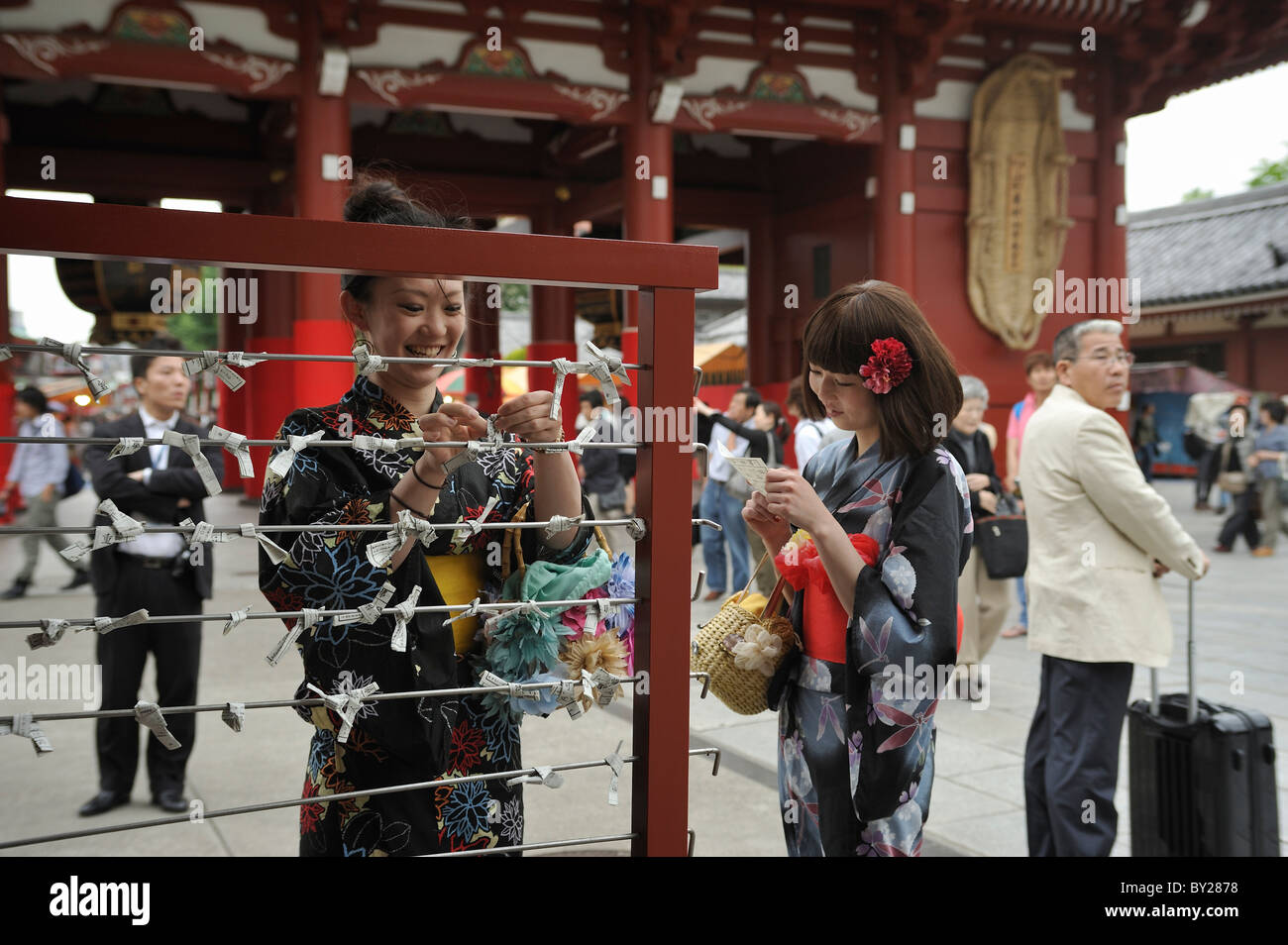 Young Japanese women dressed in kimonos knotting and reading horoscopes at Sanja Matsuri, Asakusa, Tokyo, Japan Stock Photo