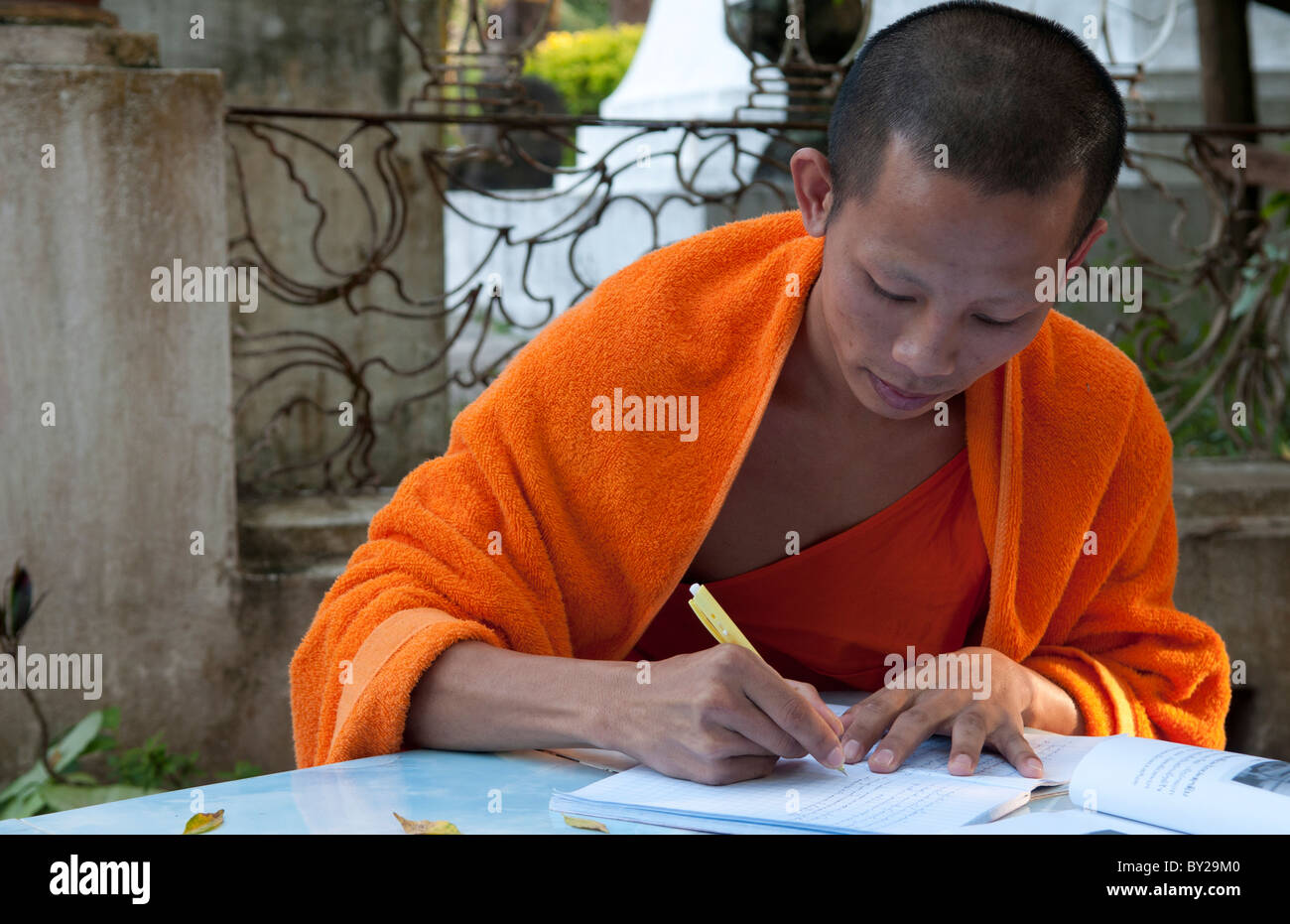 Luang Phabang Laos Lao monk relaxing and writing portrait in garden Asia Asian Stock Photo